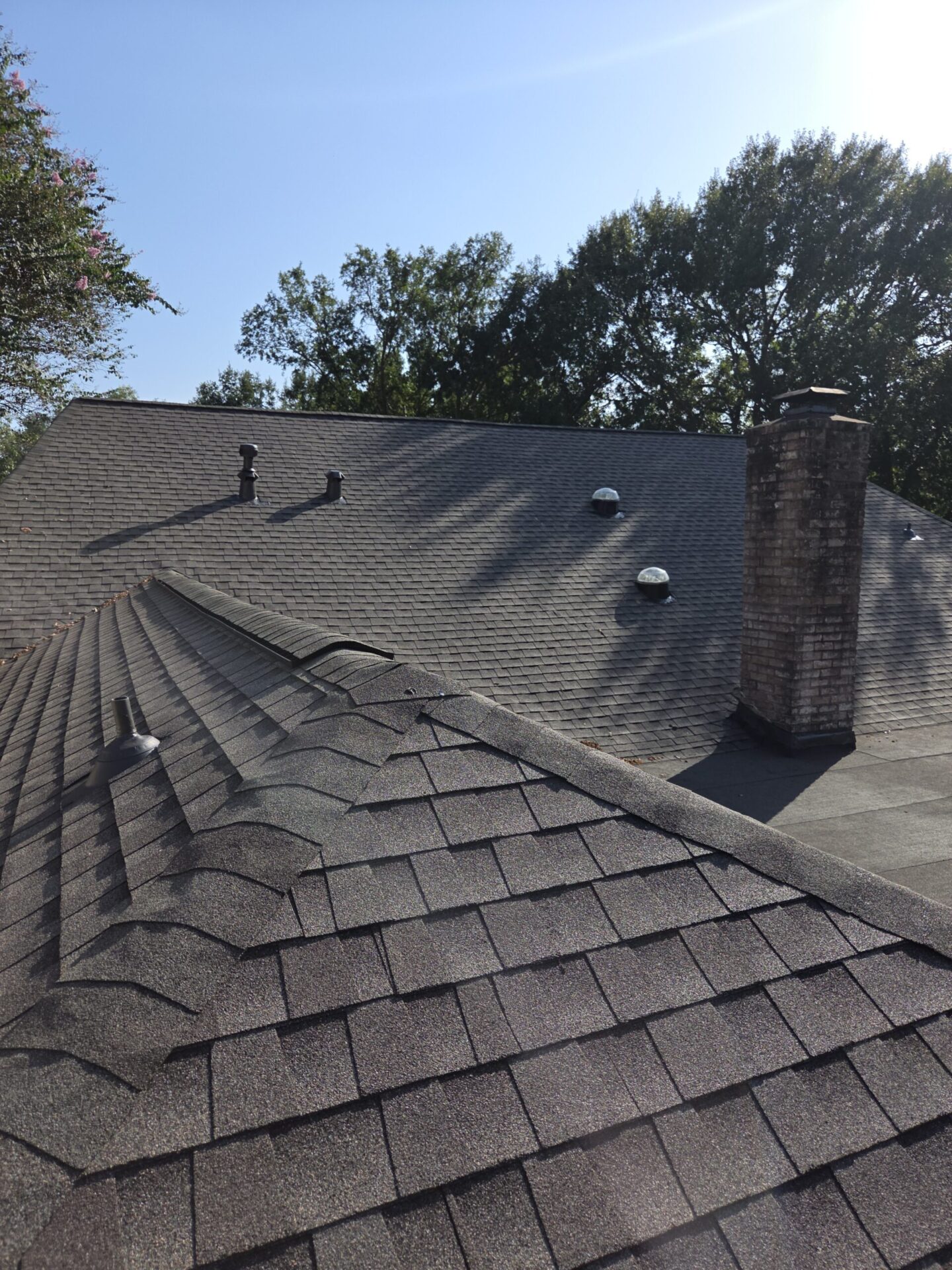 Shingle roof with chimney and vents during a maintenance inspection in Fort Bend County